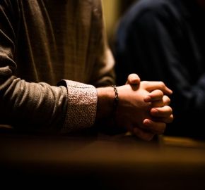 Manos de hombre entrelazadas en posición orante